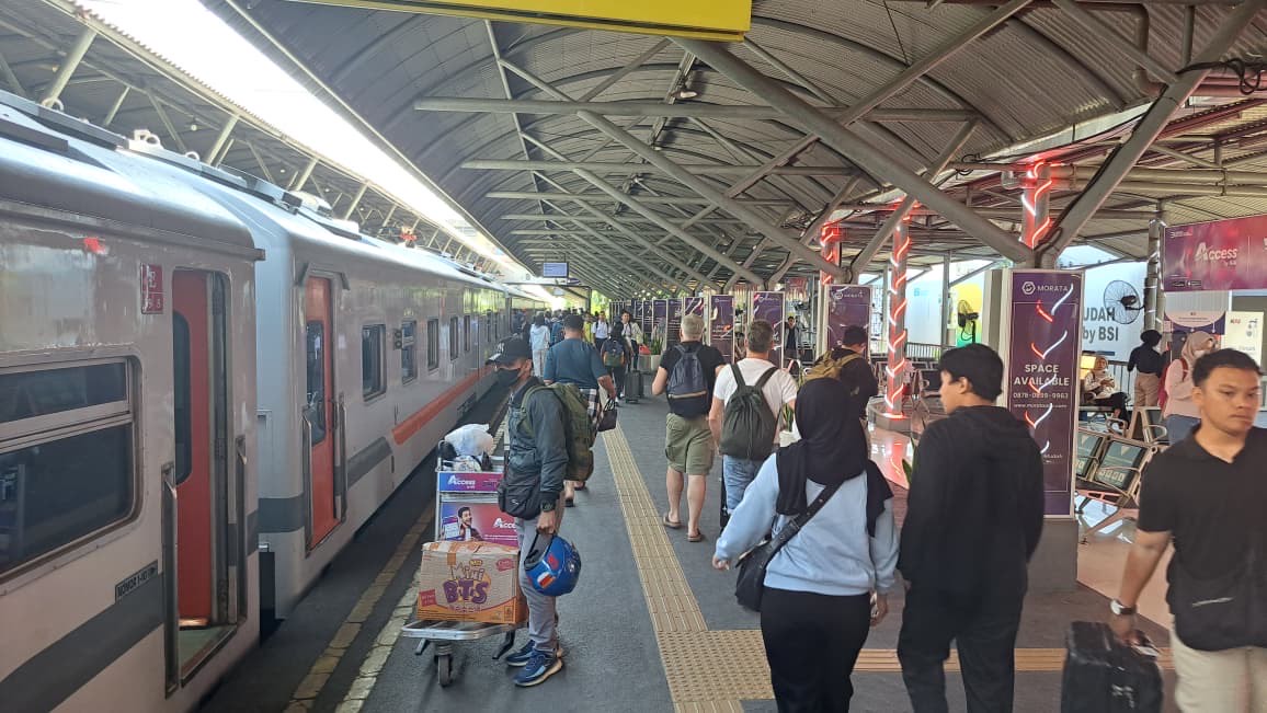 Sejumlah penumpang yang berada du Stasiun Gubeng hendak menaiki kereta api, Senin (18/8/2025).